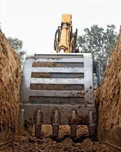 Excavator bucket working in deep trench