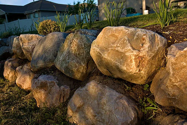 Natural boulder retaining wall with landscaping