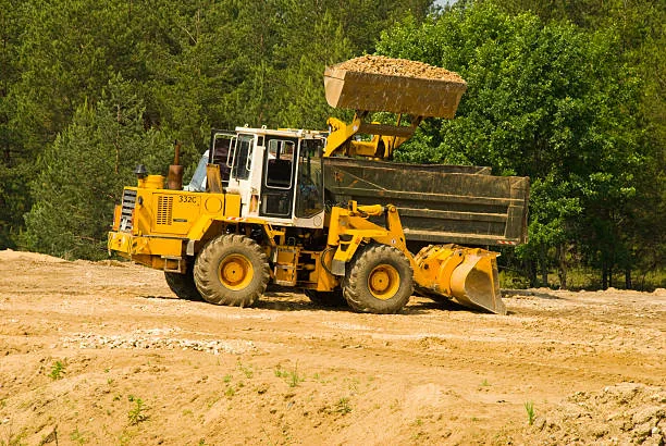 Front loader hauling fill dirt during land clearing