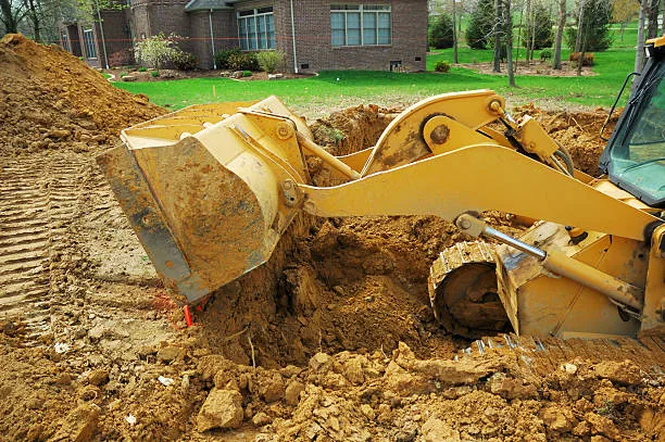 Backhoe excavating residential yard for underground work