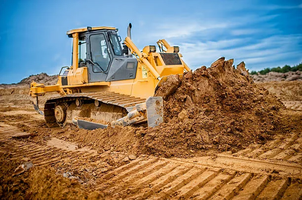 Bulldozer pushing and grading soil on open job site